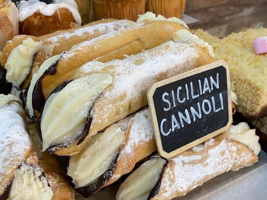 Freshly filled Sicilian cannoli with ricotta and pistachio at a pastry shop in Palermo