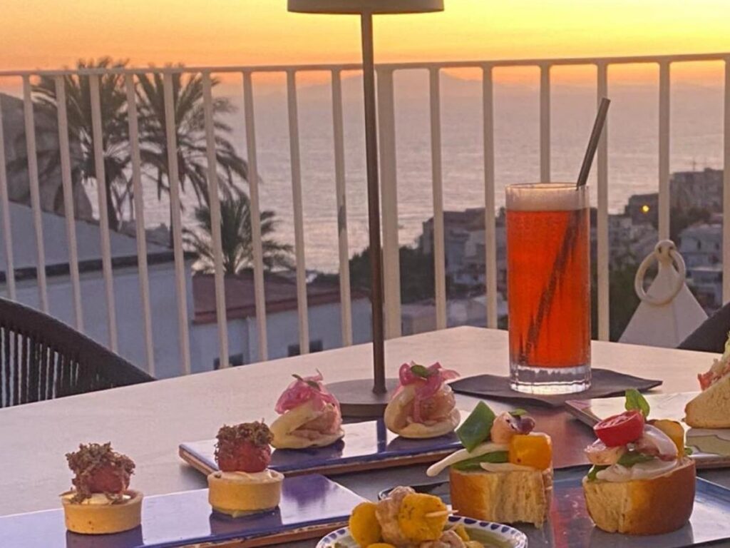 Aperol spritz and olives on a seaside terrace in Sorrento at golden hour.