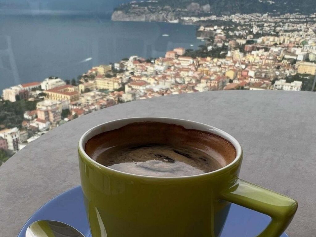 Local sipping espresso at an outdoor café in Sorrento under lemon trees on a cool winter morning.