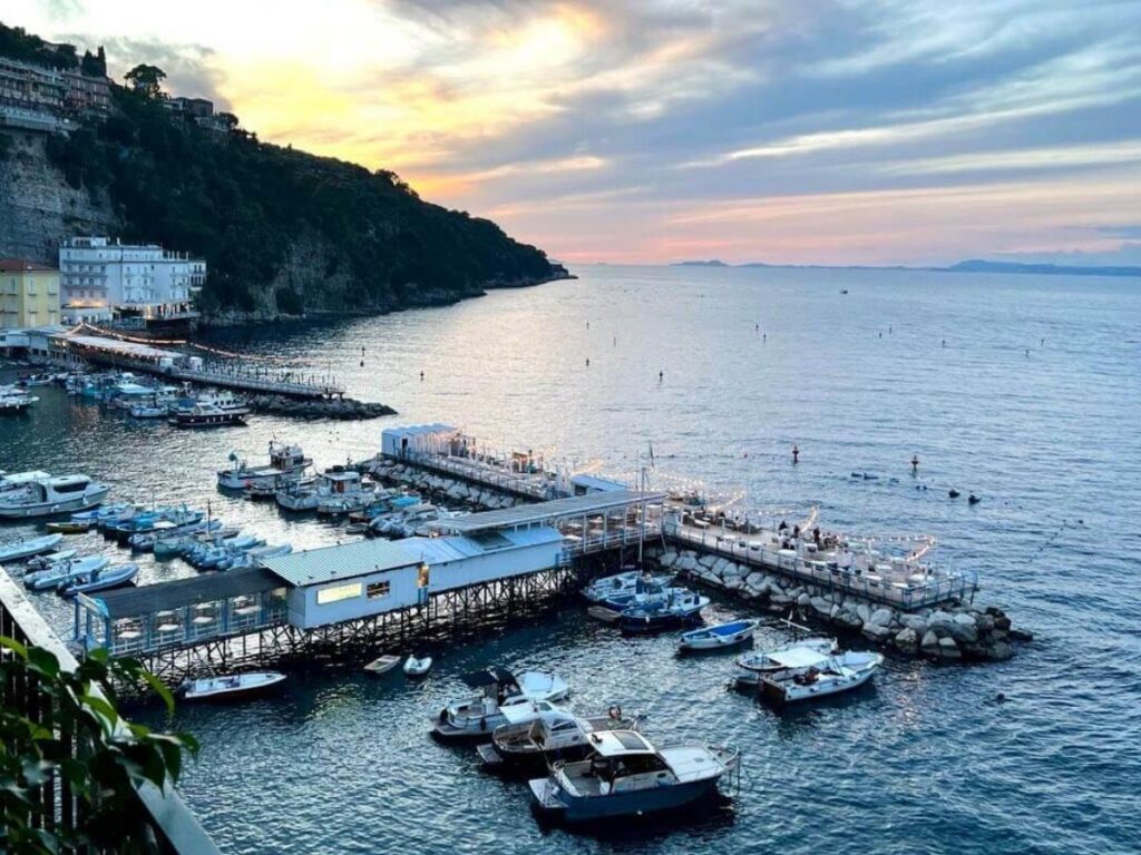 Golden autumn light over Sorrento’s marina with calm sea and fewer boats.
