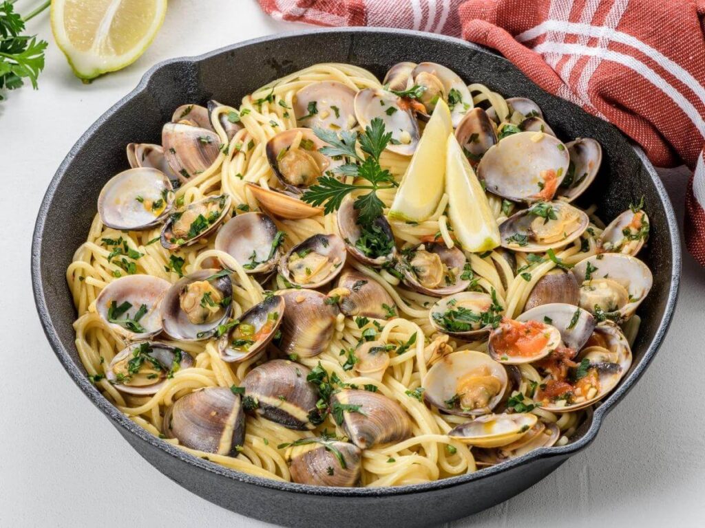 Plate of spaghetti alle vongole served at a cozy trattoria in Lignano Sabbiadoro.