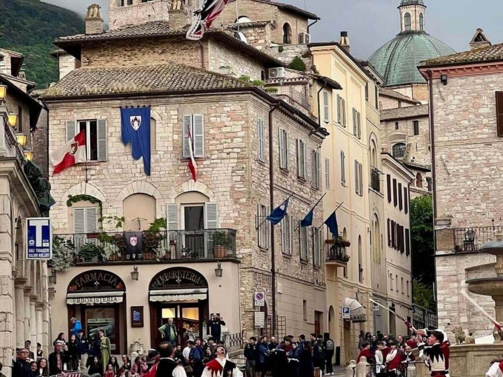 Colorful medieval costumes and street performers during Calendimaggio in Assisi in spring