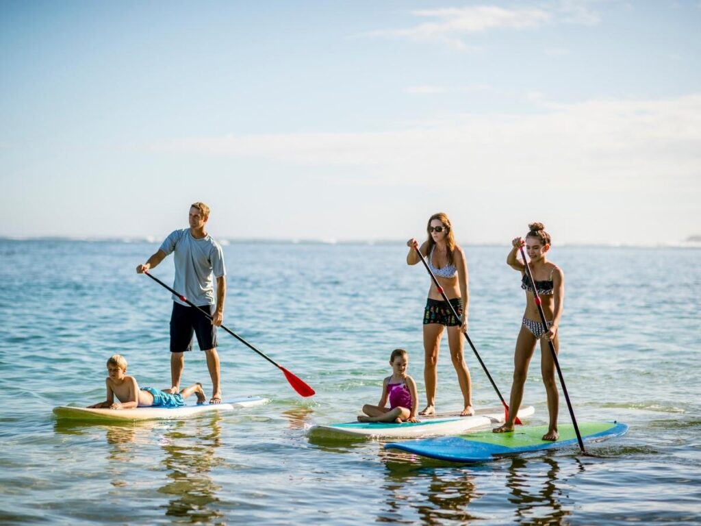 Traveler paddleboarding across calm Adriatic waters near Lignano Sabbiadoro
