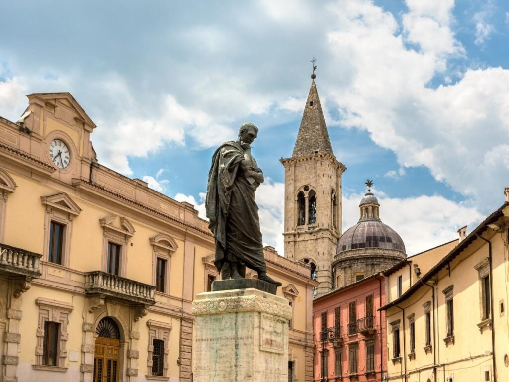 Locals strolling through Sulmona’s Renaissance piazza with gelato shops and streetlights glowing