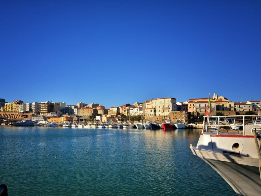 A steaming bowl of brodetto (Adriatic fish stew) served on a wooden table by Termoli’s fishing port.