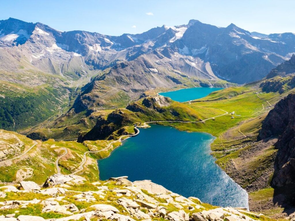 Wild ibex standing on a rocky ridge in Gran Paradiso National Park with distant glaciers behind.