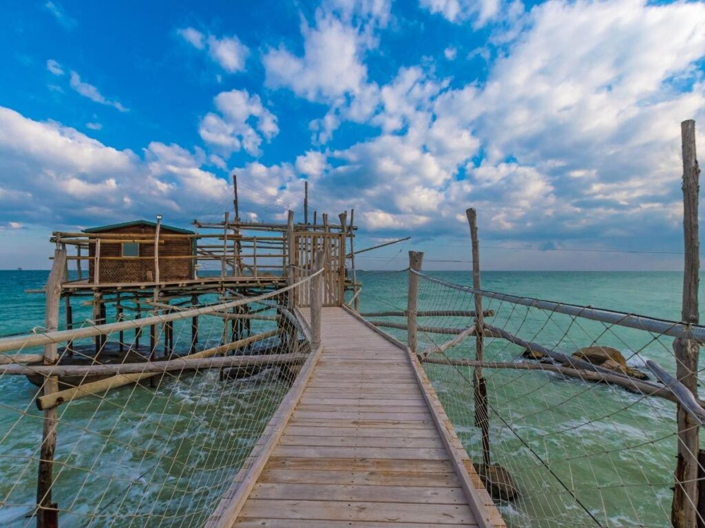 Summer evening on the Trabocchi Coast with people dining on a trabocco and colorful festa lights