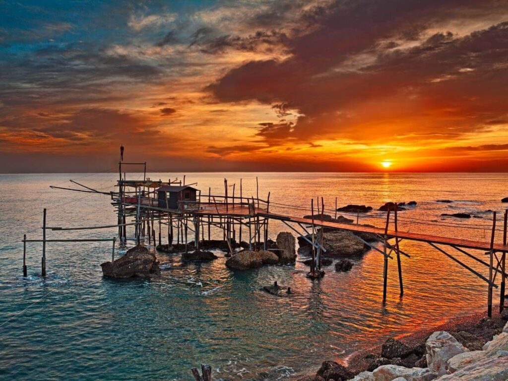 Traditional wooden trabocco fishing hut stretched over the Adriatic Sea with nets and waves below