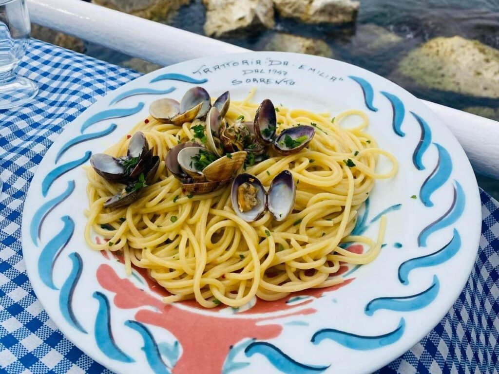 Seafood lunch with spaghetti alle vongole at Trattoria da Emilia, tables overlooking the water in Marina Grande.