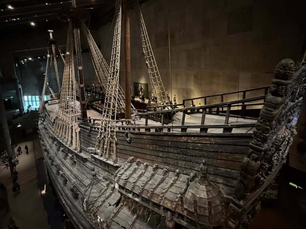 The Vasa warship rising inside the museum, visitor silhouettes below.