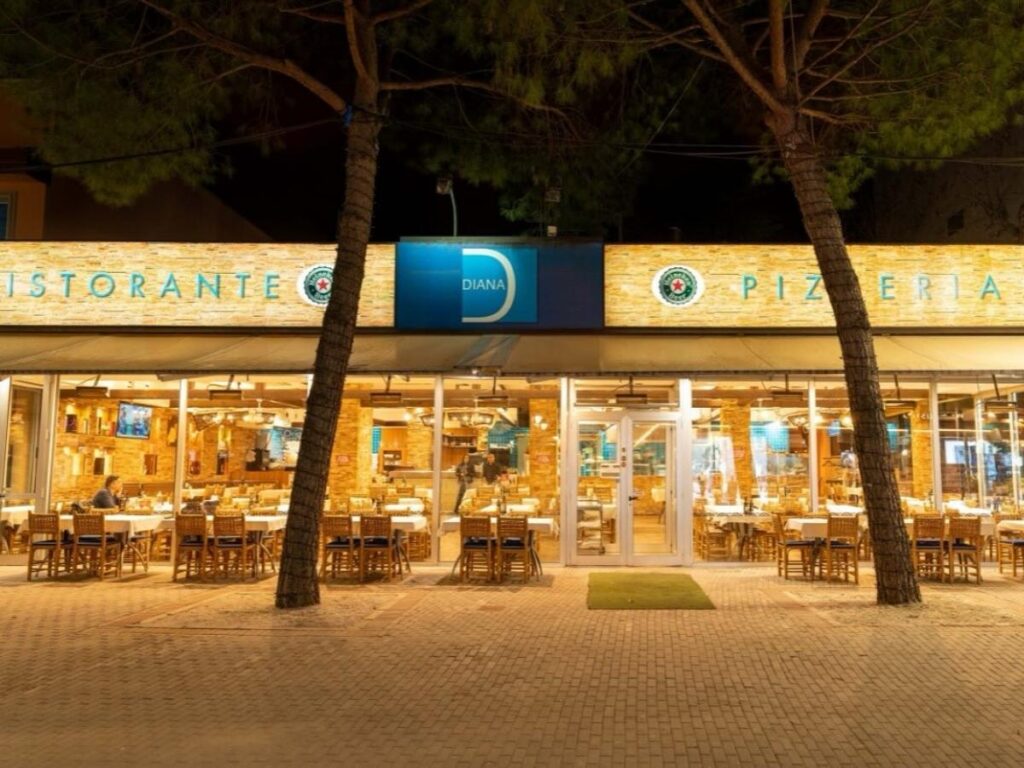 People walking under twinkling lights along Viale Ceccarini in Riccione after sunset