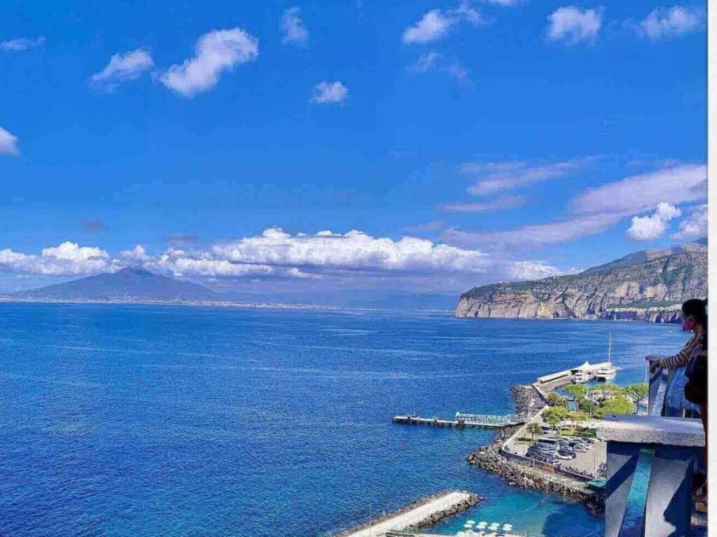 Panoramic sunset view from Villa Comunale Park overlooking the Bay of Naples and Mount Vesuvius.