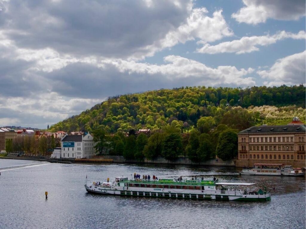 Vltava River with multiple historic bridges and riverside buildings seen from a small sightseeing boat.