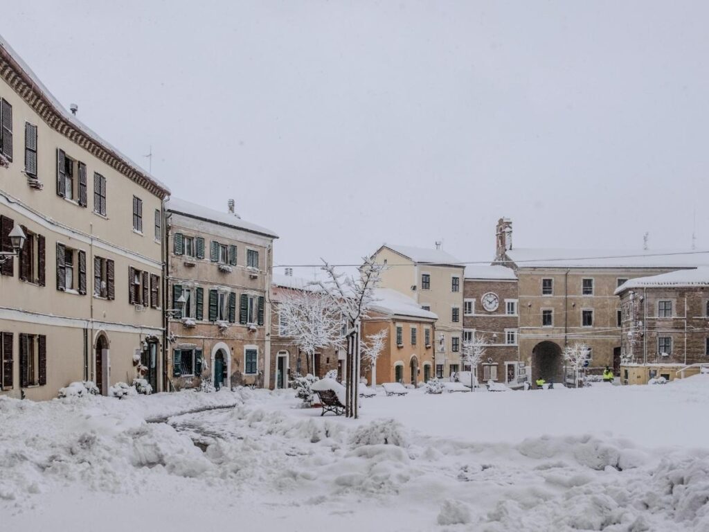 Perugia town square at dusk with Christmas lights and a steaming cup of coffee on a cafe table