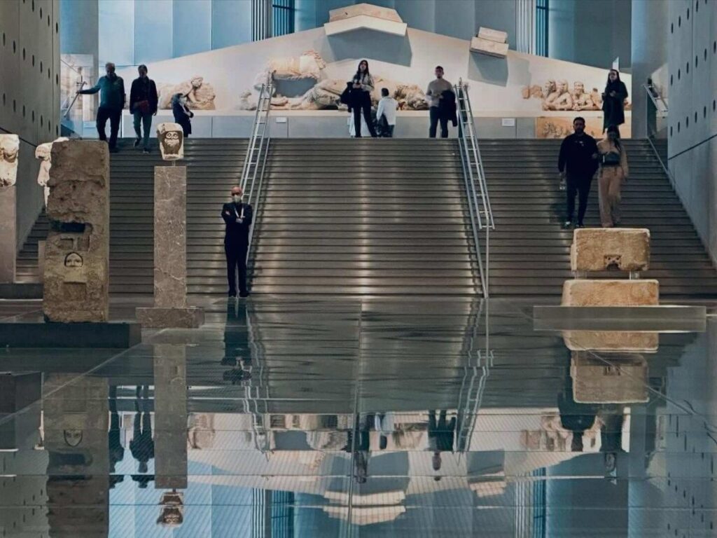 Interior of the Acropolis Museum with the glass display floor revealing ancient ruins beneath visitors’ feet