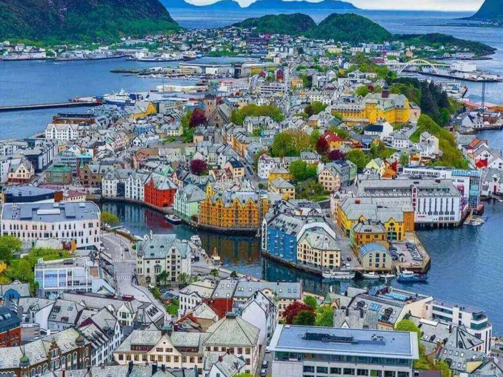 Person walking along the harbour in Ålesund under a light rain with an umbrella