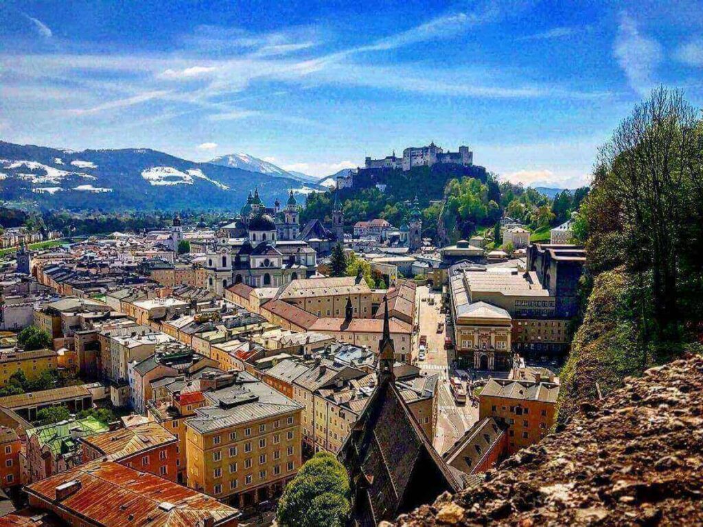 Historic cobblestone street in Salzburg’s Altstadt with baroque buildings and shop signs