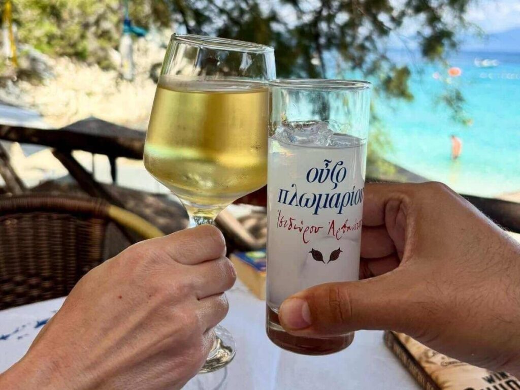“Cold drinks on a table overlooking the clear blue water of Antipaxos
