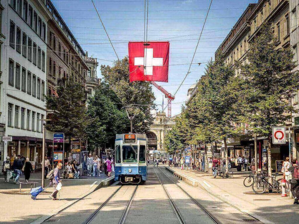 Morning scene on Bahnhofstrasse with pedestrians and tree-lined sidewalks