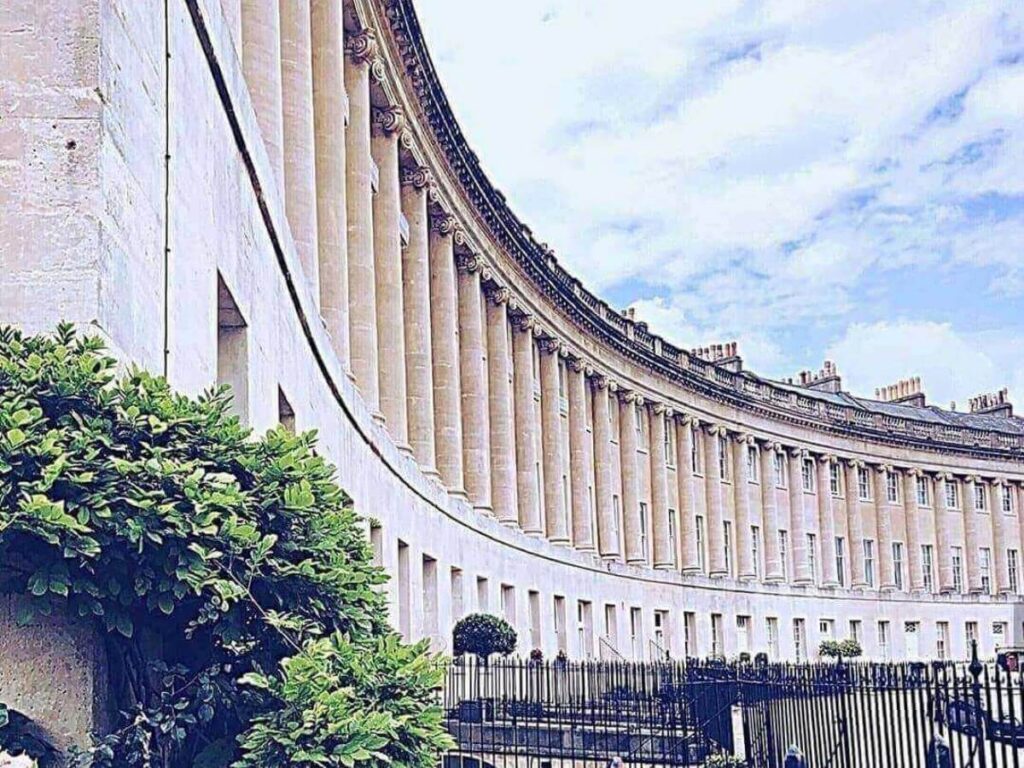 Morning view of the Royal Crescent with soft light and wide grassy lawns in front