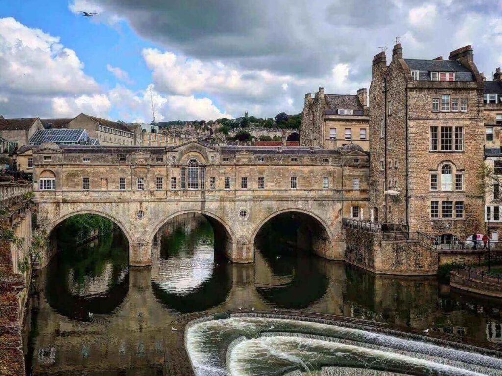 Riverside footpath below Pulteney Bridge showing the stone arches from the lower level