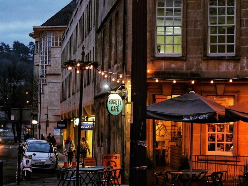 Coffee and pastry on a wooden table inside Society Café with light coming through large windows