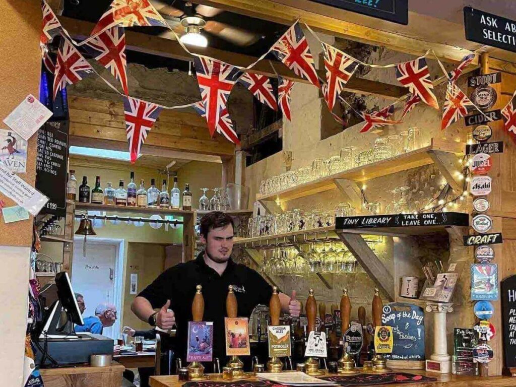 Warm interior of a traditional Bath pub with wooden beams and soft lighting