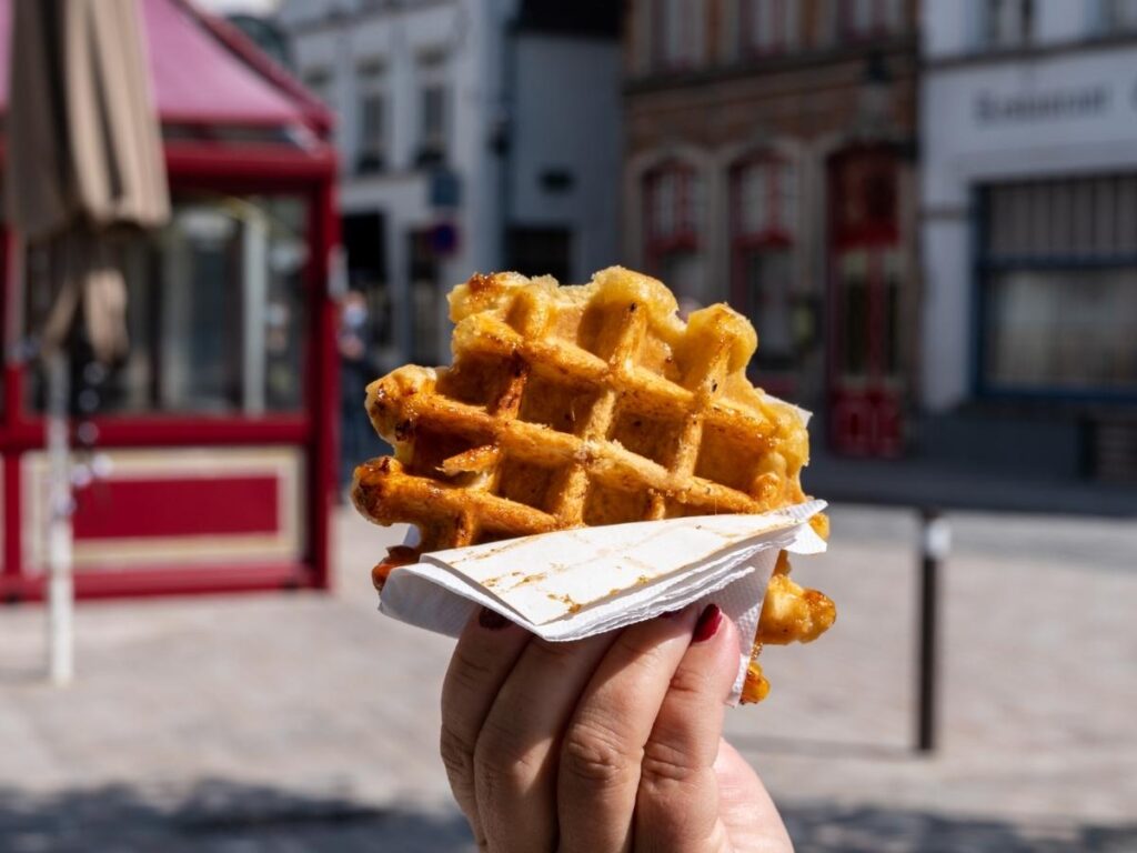 Fresh Belgian waffle dusted with sugar served from a street window in Bruges.