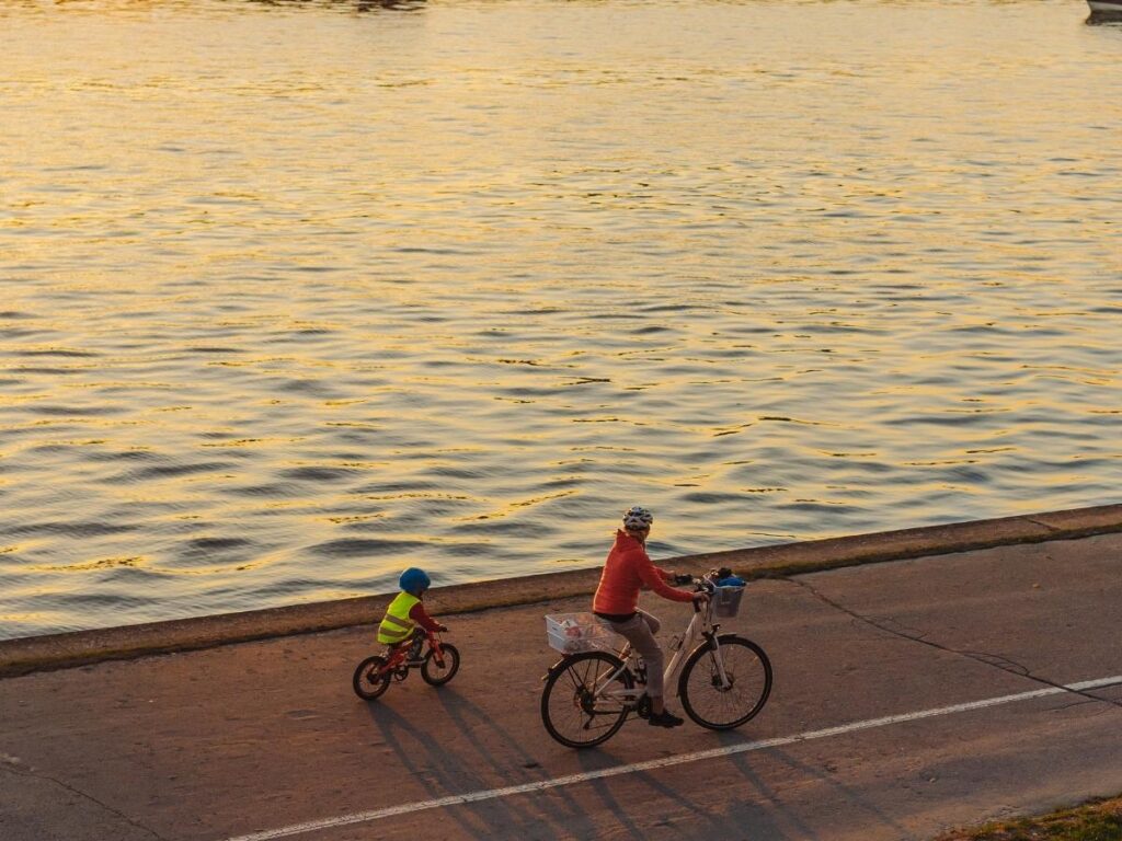 Cyclist riding along the palm-lined promenade at Faliro with the sea beside them