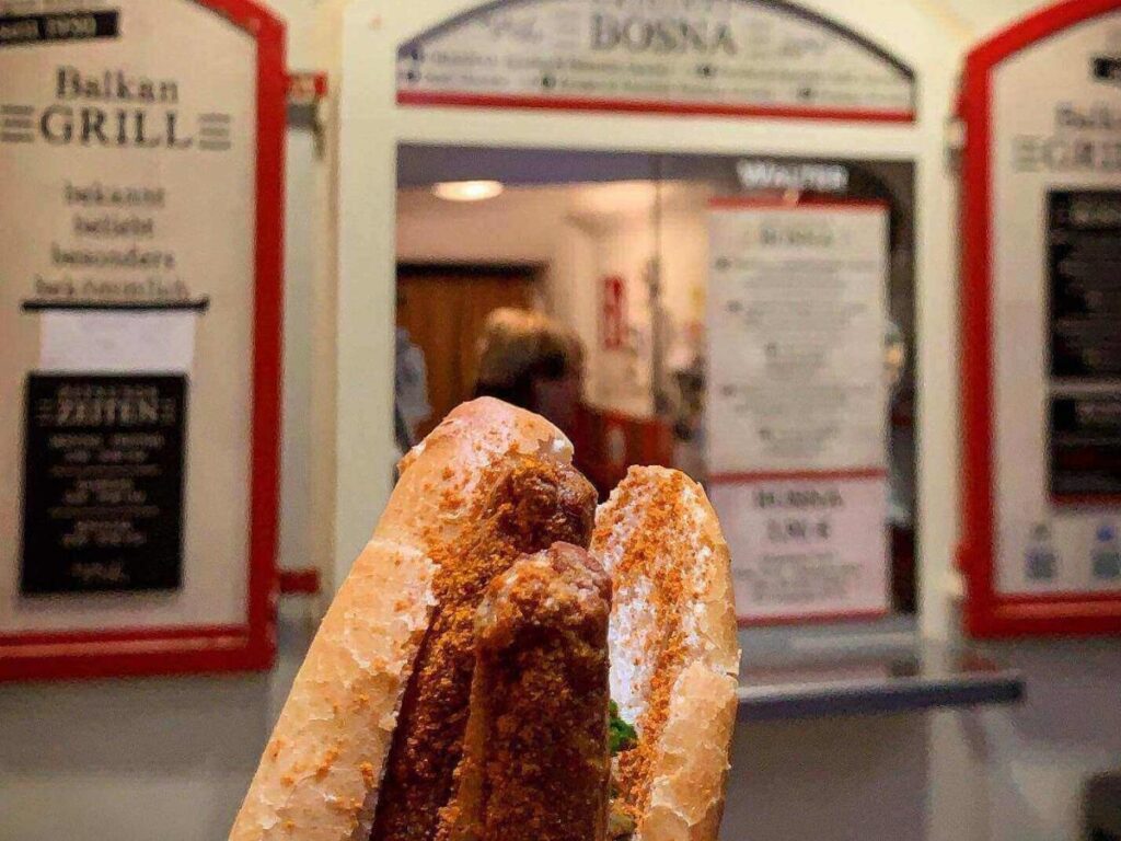 Bosna sausage in bread, street vendor preparing it in the Old Town
