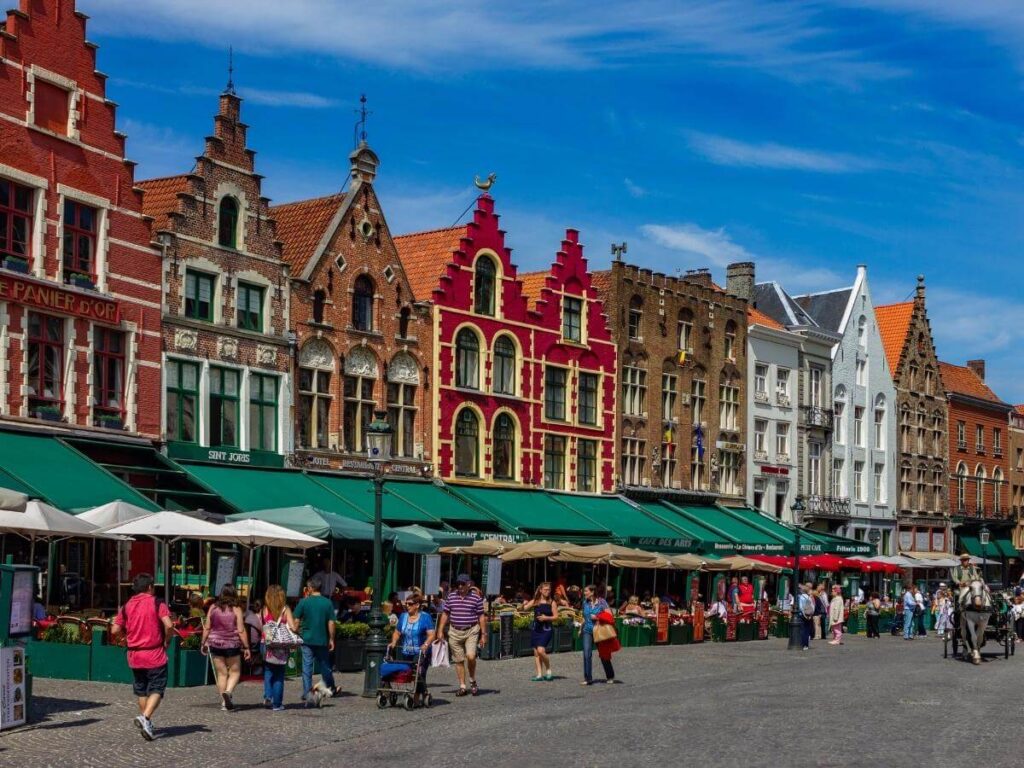 Colourful guild houses and the Belfry in Bruges Markt Square during quiet morning hours