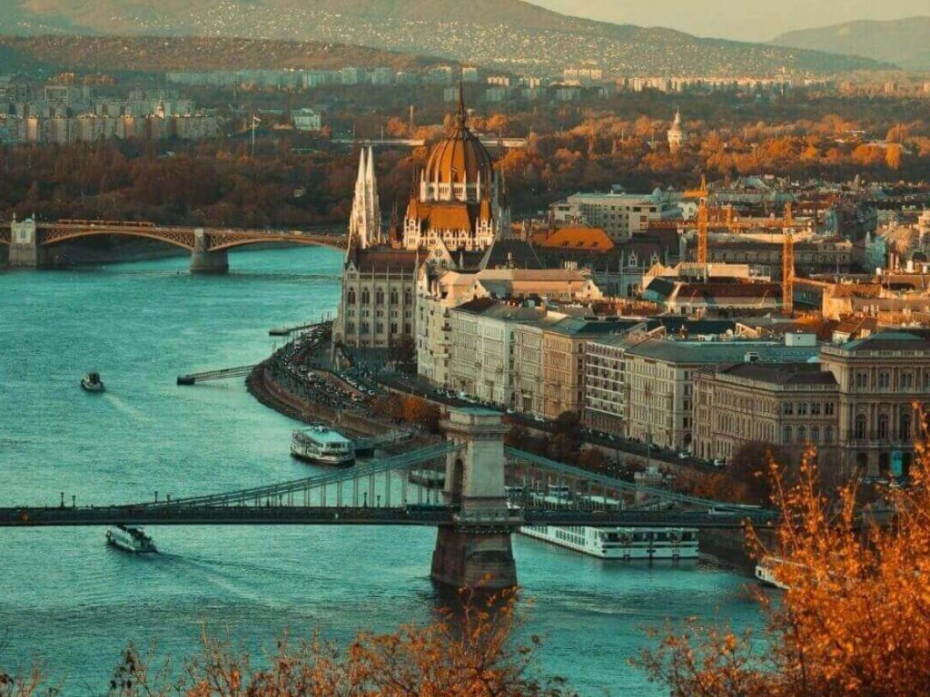 Autumn trees along the Danube River in Budapest with clear skies and warm golden light