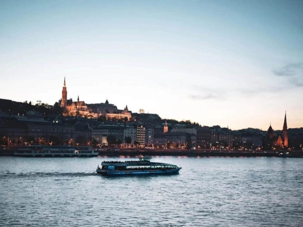 Sunset view of Budapest from a Danube River cruise with glowing city lights