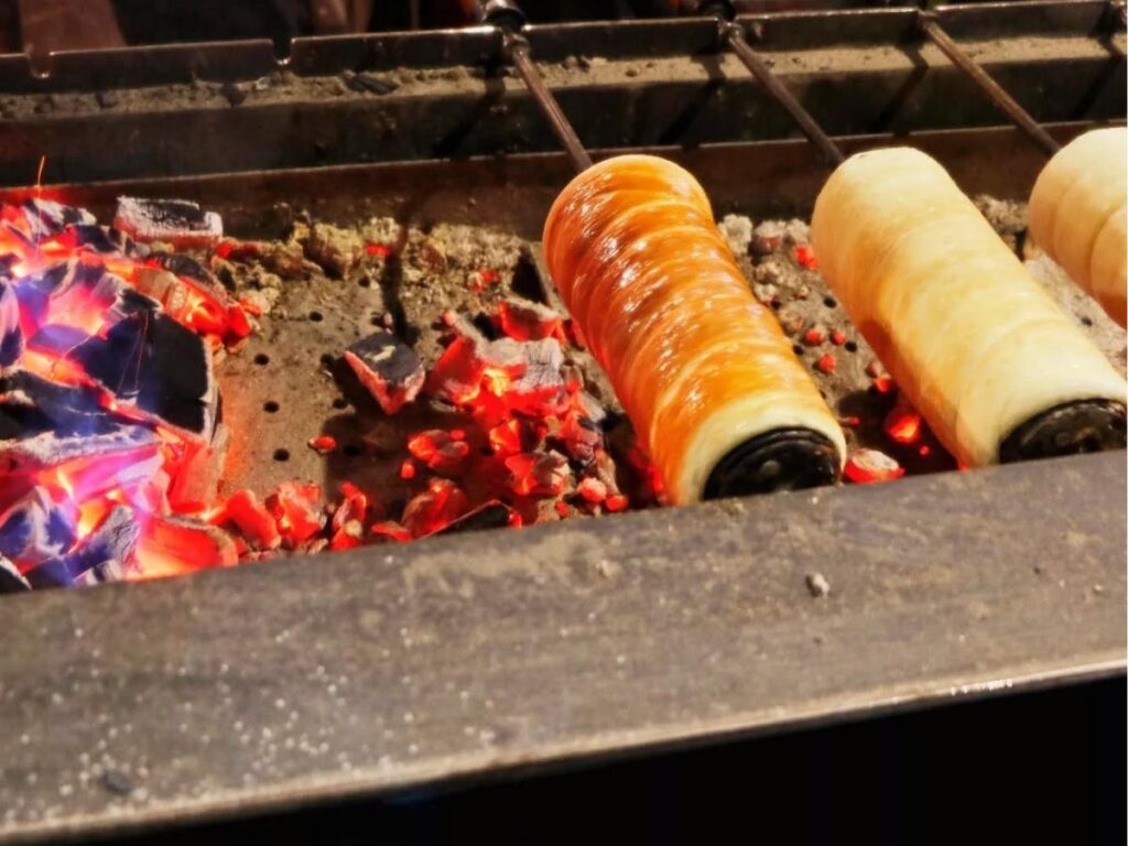 Traditional Hungarian chimney cake roasting on a spit at a Budapest street stall
