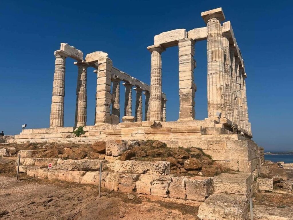 Early autumn sunset at Cape Sounion with long shadows and a soft golden sky