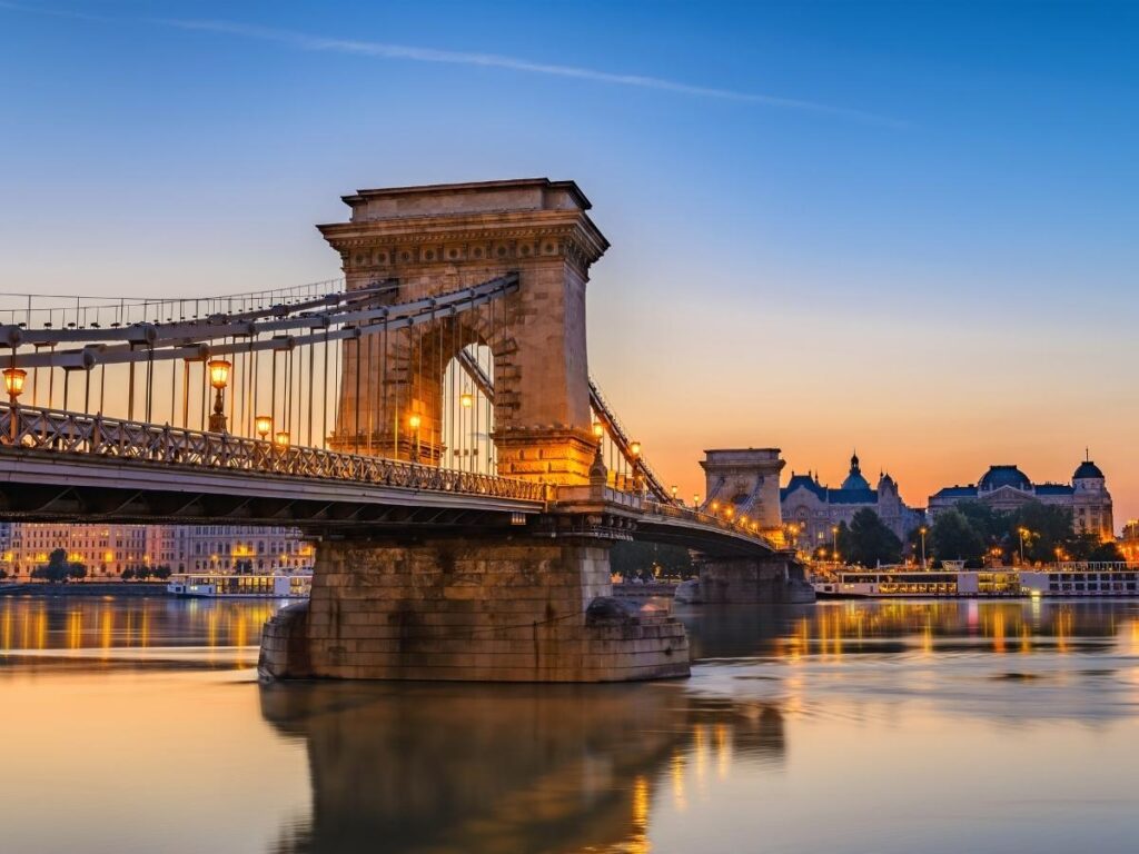 Chain Bridge illuminated at night with reflections on the Danube in Budapest