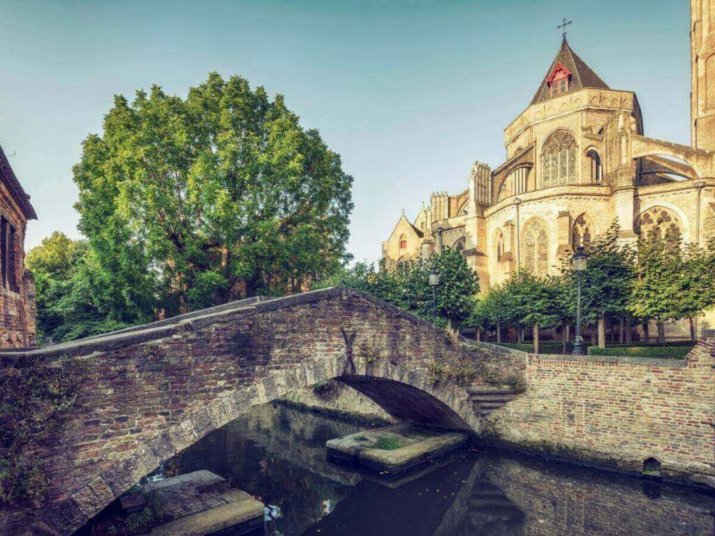 Canal-side view of the Church of Our Lady and the Gruuthuse Bridge in Bruges