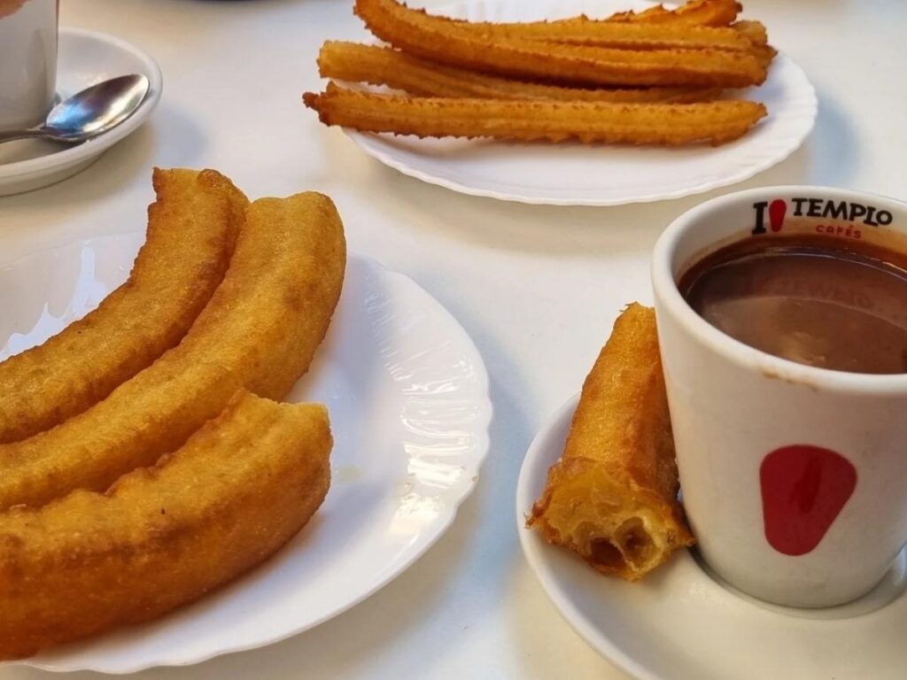 Plate of churros with thick hot chocolate in an evening café