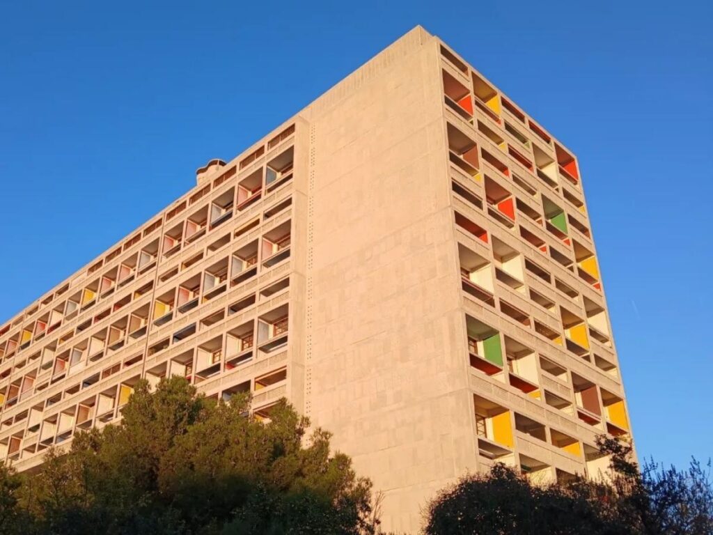 Le Corbusier’s Cité Radieuse rooftop terraces with clean concrete lines and Marseille skyline beyond