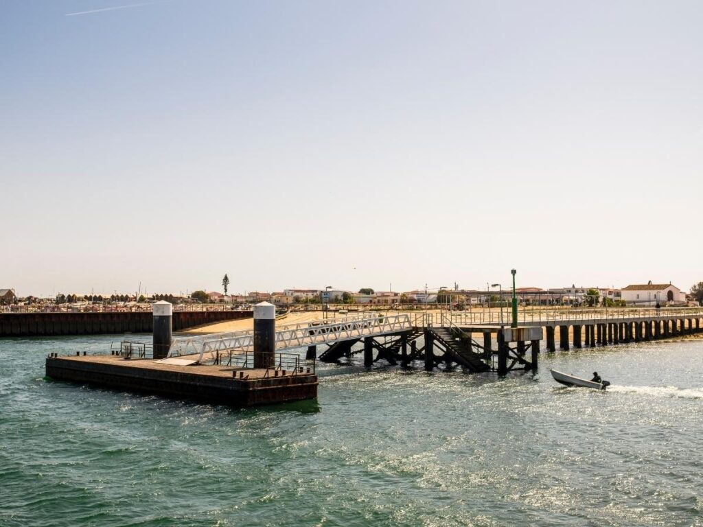 Colorful fishing boats moored at Culatra Island harbor, near Olhão, Portugal.
