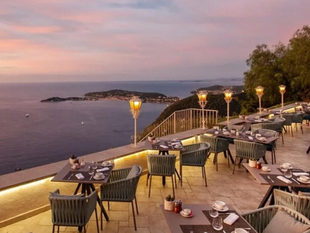 Outdoor café table along Èze’s main cobblestone lane during a quiet morning