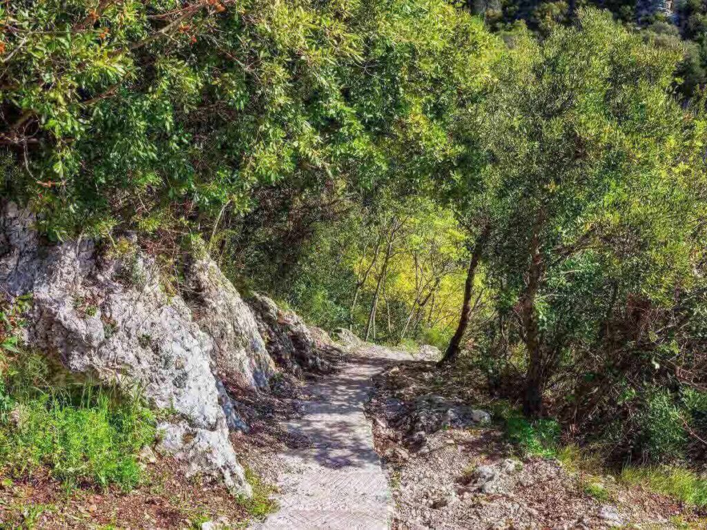Trailhead of the Nietzsche Path in Èze-sur-Mer with rocky steps leading uphill toward the village
