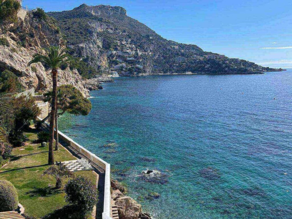 Cup of coffee on a table overlooking the water at Èze-sur-Mer before hiking up to Èze Village