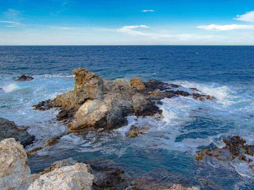 Pebble beach and clear blue water at Èze-sur-Mer below the hilltop village