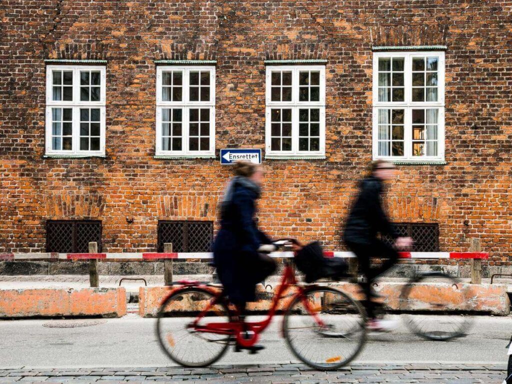 Family cycling along a path near the canals in Copenhagen.
