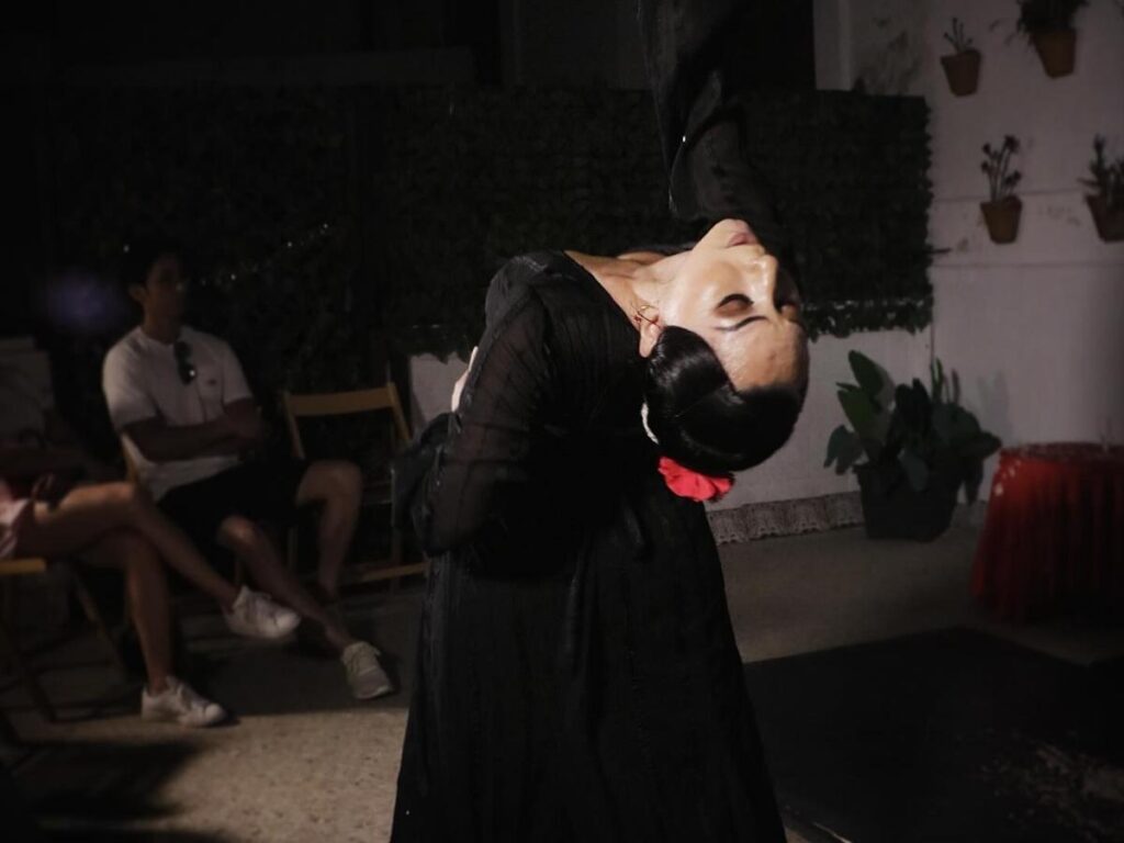 Flamenco dancer mid-movement in a small, intimate tablao in Seville