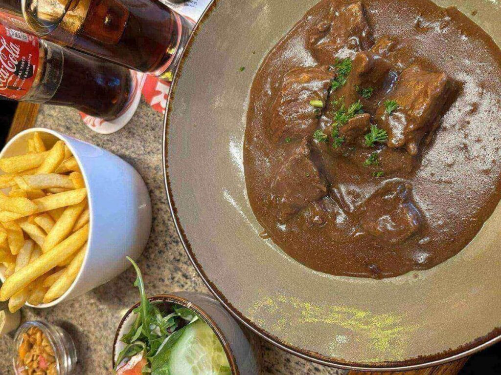 Traditional Flemish stew served with fries in a cosy Bruges restaurant.