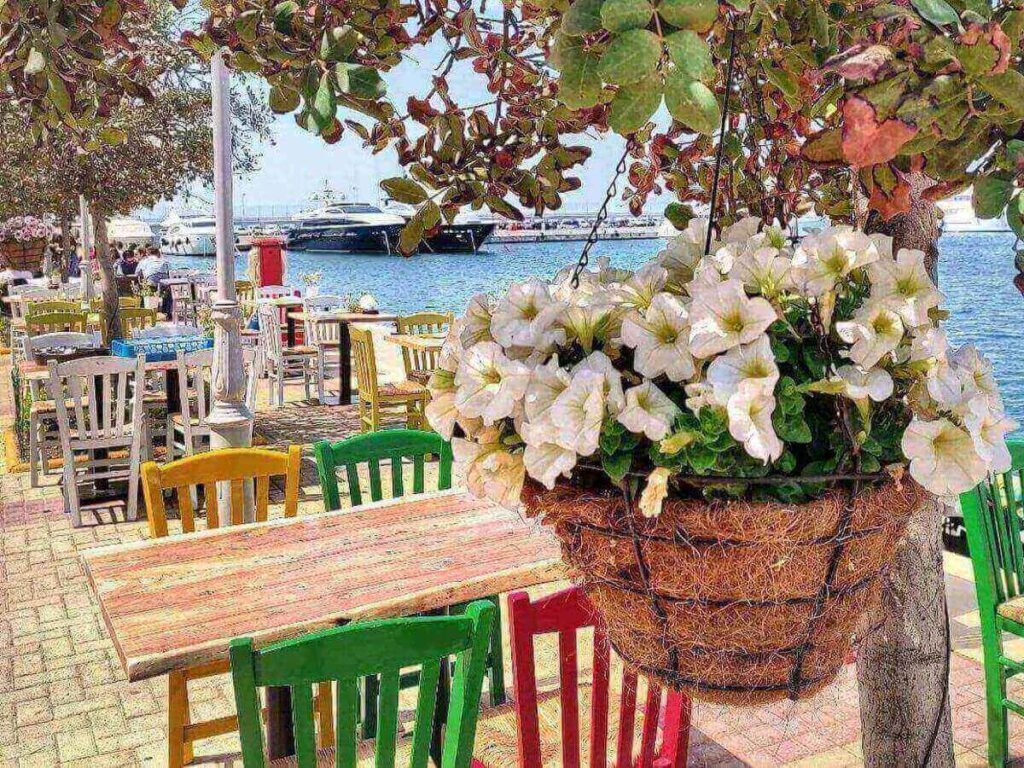 Coffee cup on a table overlooking yachts at Flisvos Marina in the soft morning light.