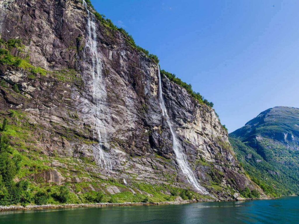 Iconic waterfall and cliff view in Geirangerfjord, a full-day trip from Ålesund