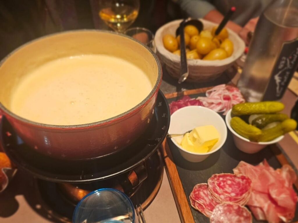 Traditional Swiss cheese fondue served in a rustic pot with bread on the side